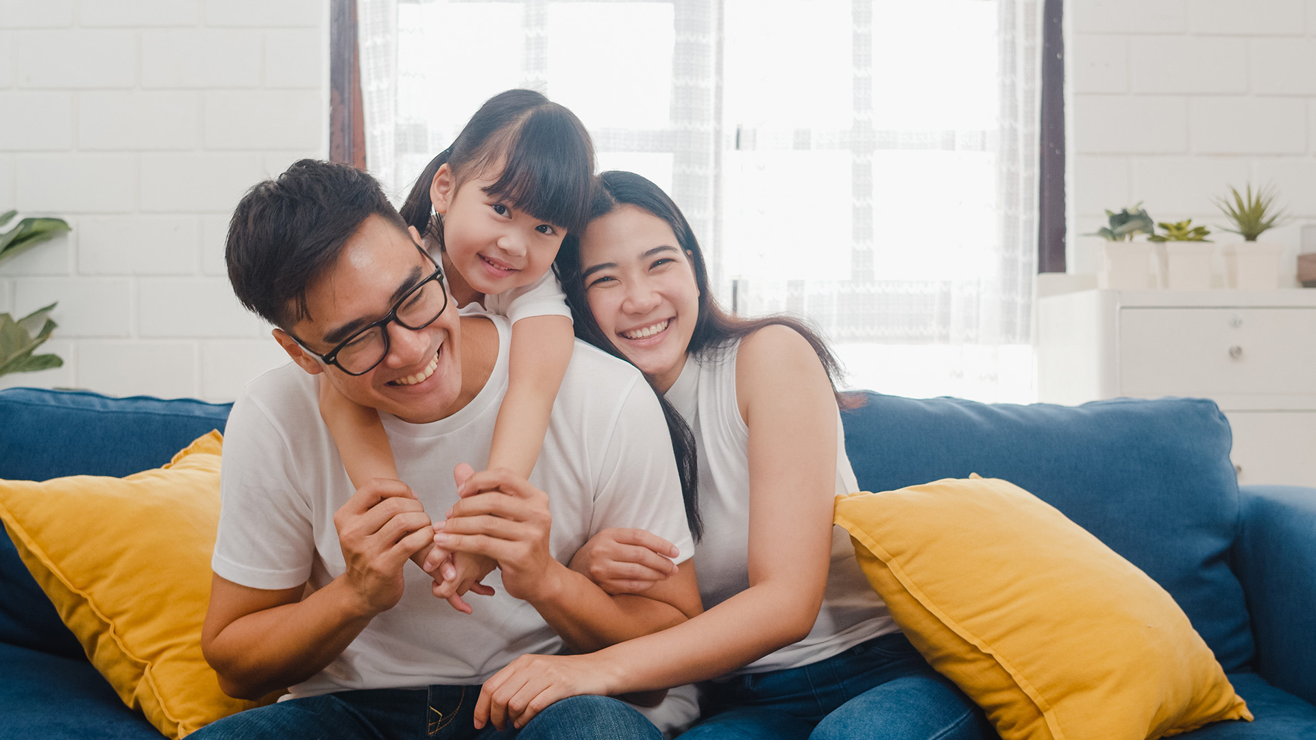 Family hugging each other on their couch